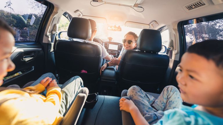 A family in their car after choosing financing through a credit union instead of a dealership